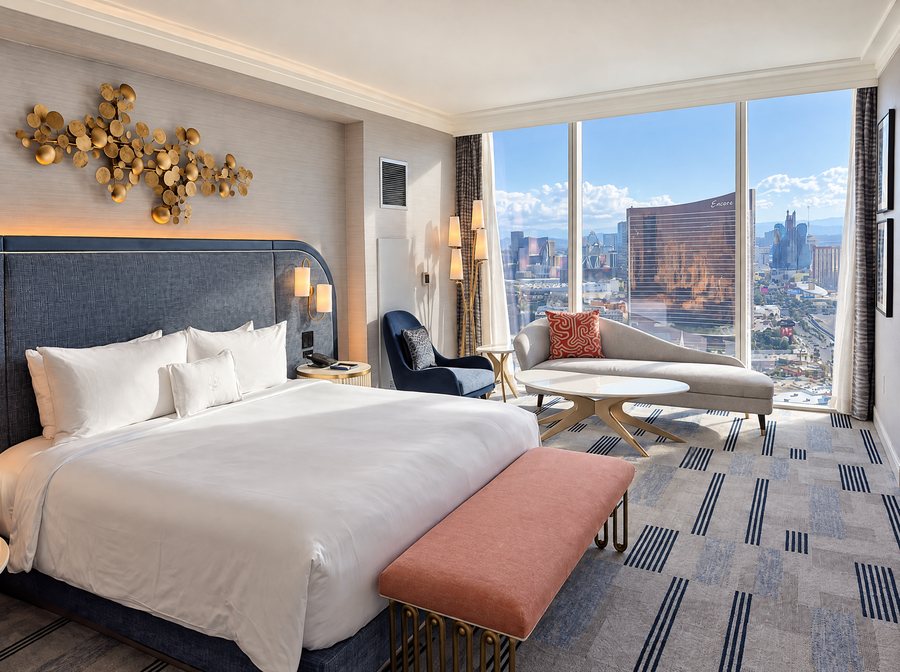 Fontainebleau Las Vegas, a guest room with a king bed and a chaise at a floor to ceiling window over the Strip